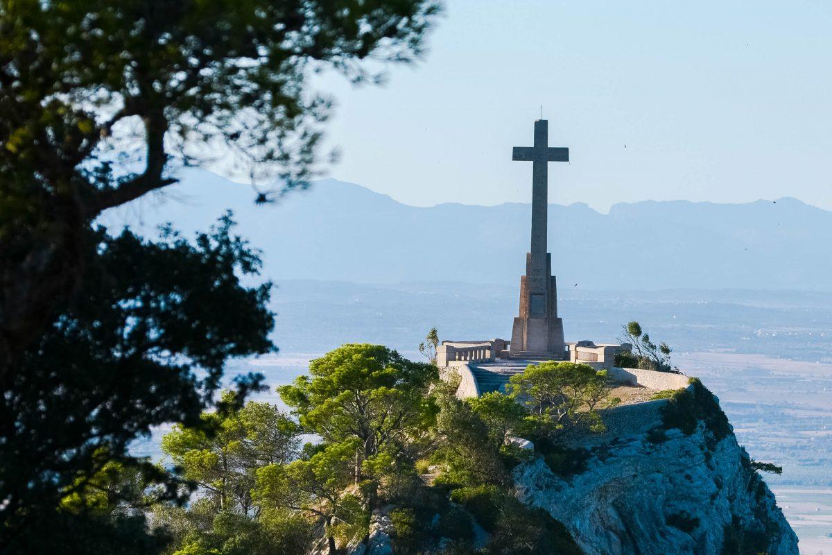 The monumental stone cross Creu d'es Picot rises to the sky on a hill north of the monastery of Sant Salvador, Mallorca, Spain - © James Camel / franks-travelbox