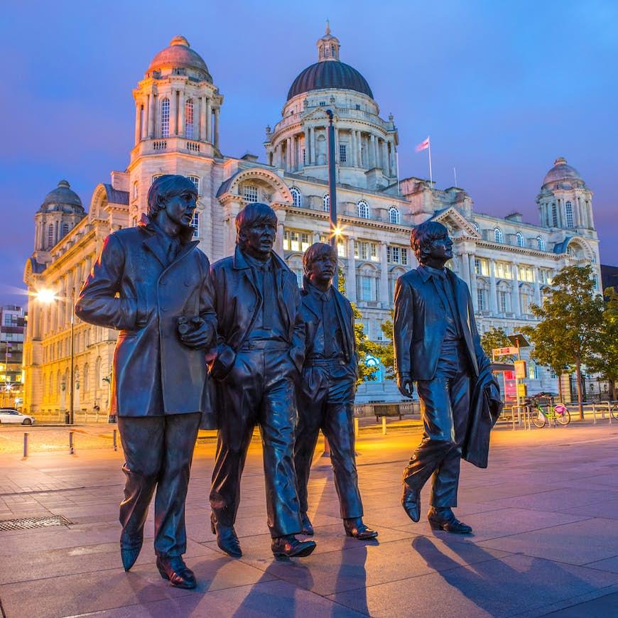Statue des Beatles à Pier Head à Liverpool la nuit. 